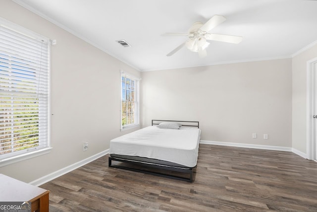 bedroom with ornamental molding, multiple windows, dark wood-type flooring, and ceiling fan