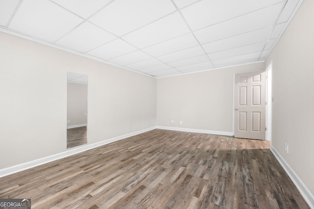 spare room with hardwood / wood-style floors and a drop ceiling