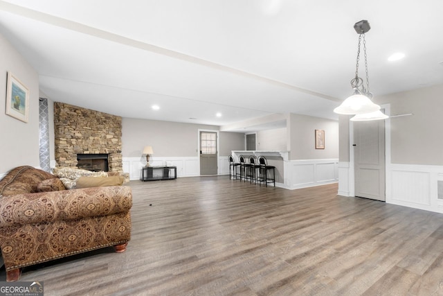 living room featuring a stone fireplace and hardwood / wood-style flooring