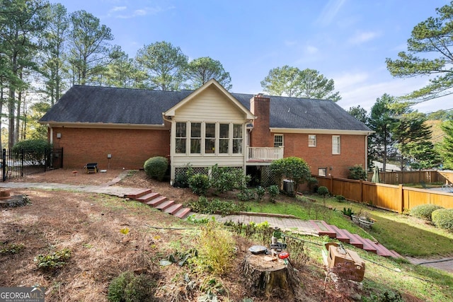 rear view of house with a sunroom and central AC