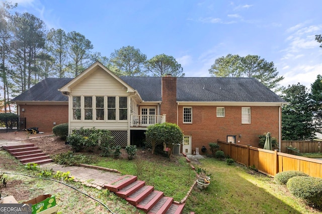 back of property featuring a sunroom and a yard