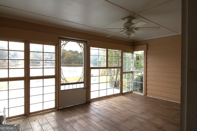 doorway to outside with ceiling fan, a water view, and dark hardwood / wood-style floors