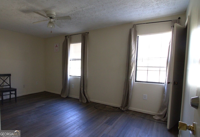 spare room with a textured ceiling, ceiling fan, and dark wood-type flooring