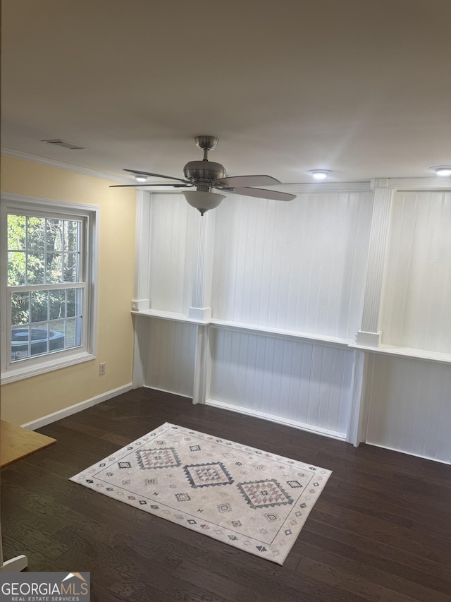 spare room with dark hardwood / wood-style flooring, ceiling fan, and ornamental molding