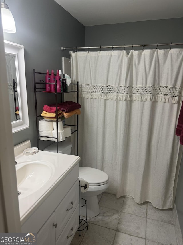 bathroom with toilet, vanity, and a shower with shower curtain