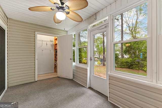 unfurnished sunroom with ceiling fan