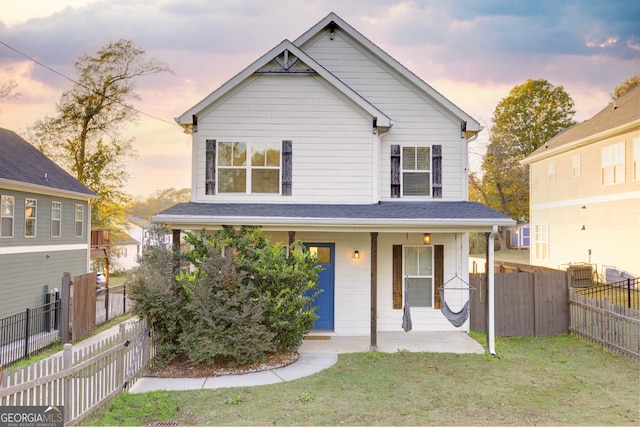 front of property with a lawn and a porch