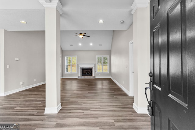 entrance foyer featuring hardwood / wood-style floors, high vaulted ceiling, ceiling fan, a fireplace, and a textured ceiling