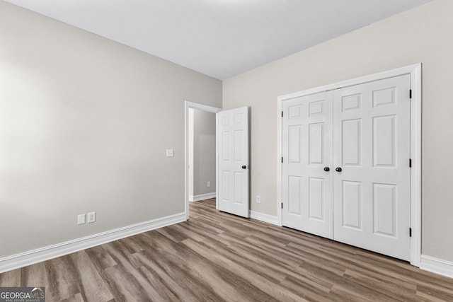 unfurnished bedroom featuring wood-type flooring and a closet