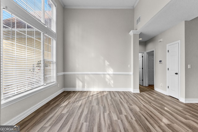 unfurnished room with wood-type flooring and ornamental molding