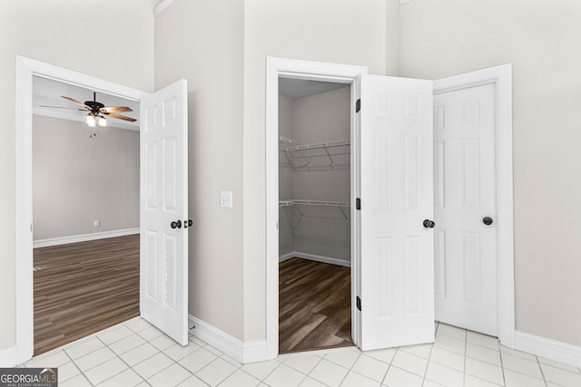 unfurnished bedroom featuring light hardwood / wood-style floors, a spacious closet, a closet, and ceiling fan