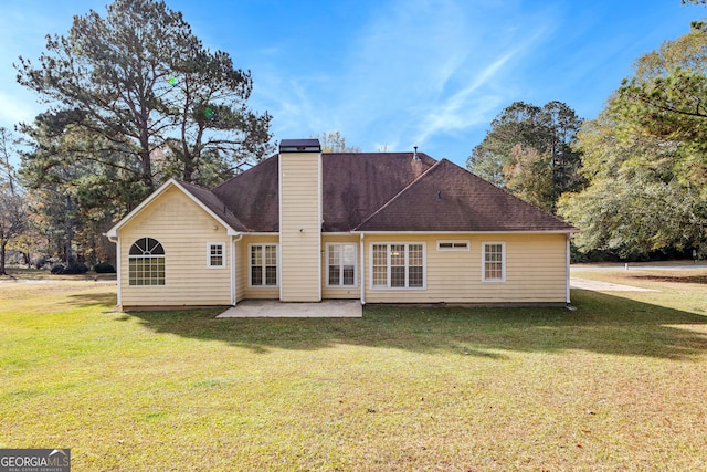 rear view of house featuring a lawn and a patio