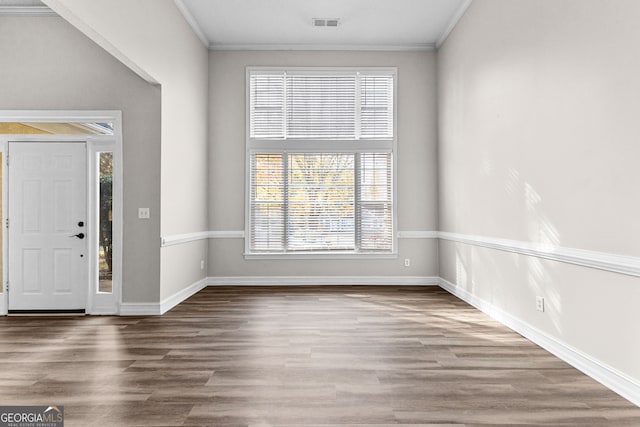 foyer featuring wood-type flooring, ornamental molding, and a wealth of natural light