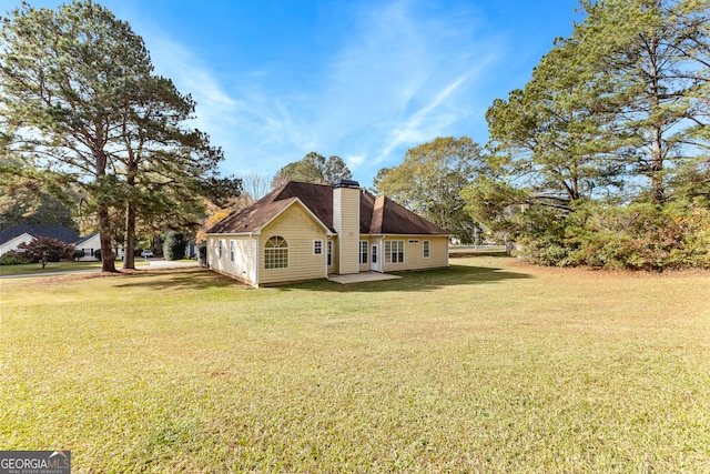 view of side of home with a lawn and a patio