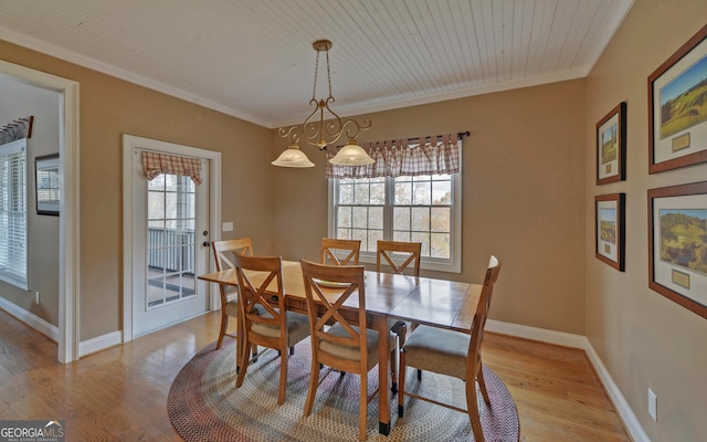 dining space featuring a chandelier, light wood-type flooring, crown molding, and wood ceiling