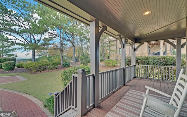 wooden terrace with a porch and a lawn