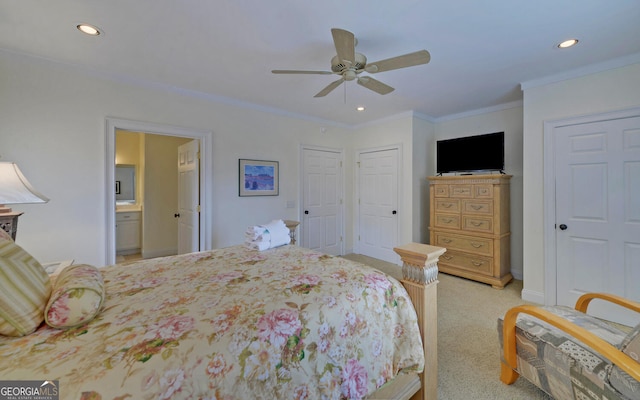 bedroom with light carpet, ensuite bath, ceiling fan, crown molding, and multiple closets