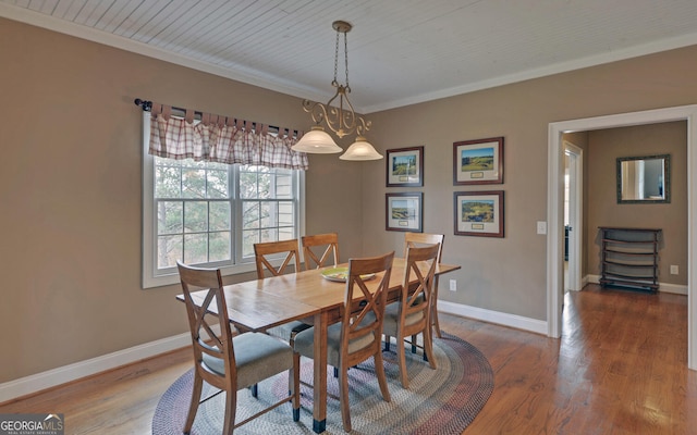 dining room featuring crown molding, hardwood / wood-style floors, and wooden ceiling