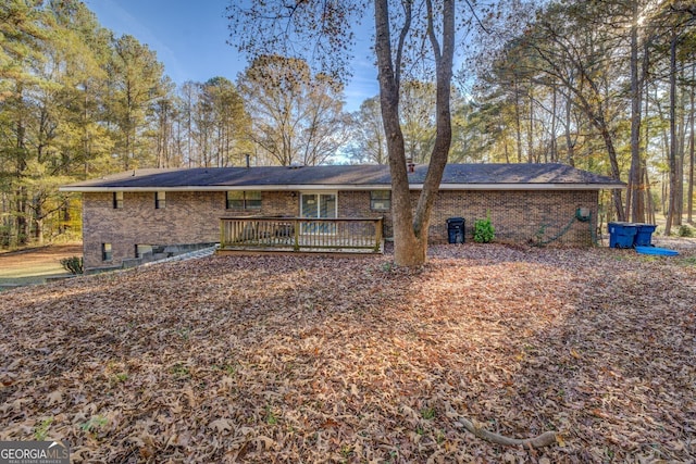 rear view of property featuring a wooden deck