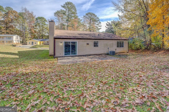 rear view of house with a yard and central AC unit