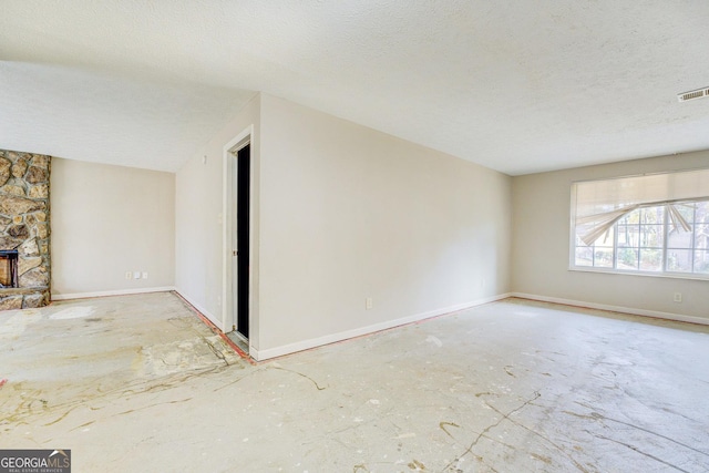 unfurnished living room featuring a fireplace and a textured ceiling