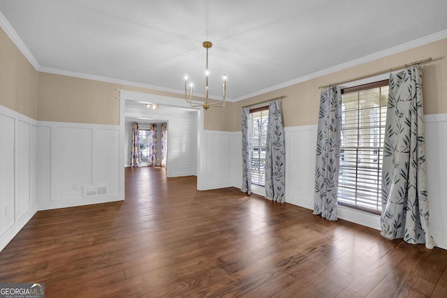 unfurnished dining area with a chandelier, dark hardwood / wood-style floors, and ornamental molding