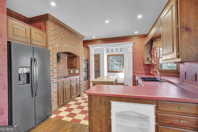 kitchen featuring kitchen peninsula, stainless steel refrigerator with ice dispenser, black electric stovetop, double wall oven, and sink