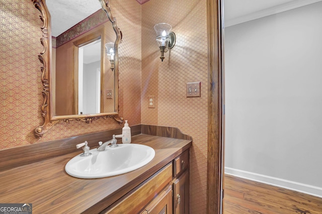 bathroom featuring vanity, hardwood / wood-style flooring, and ornamental molding