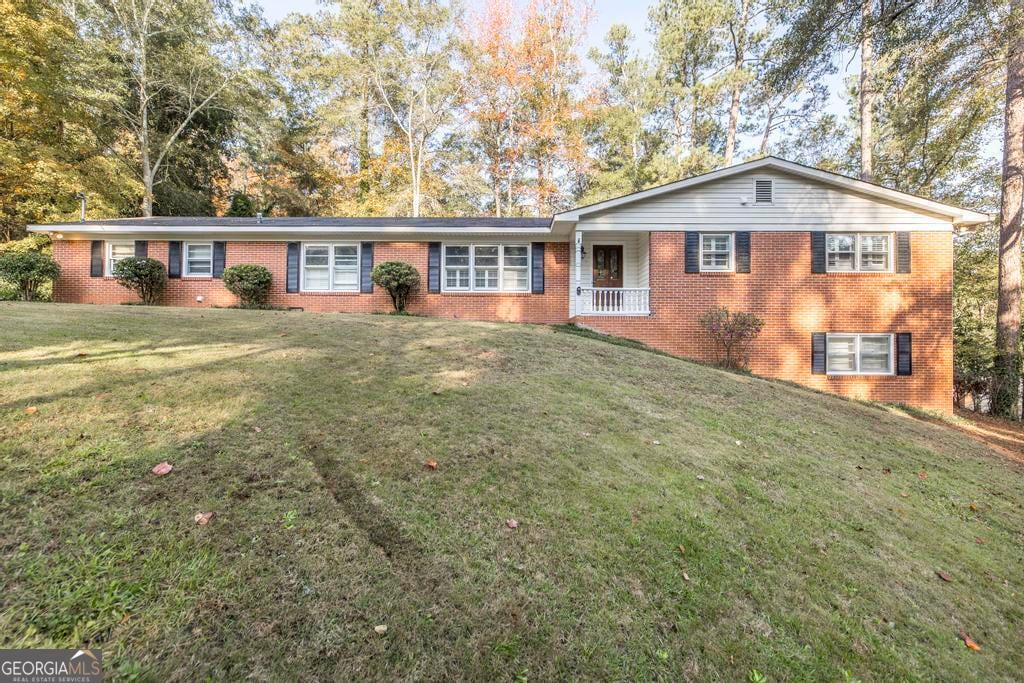 single story home with covered porch and a front lawn