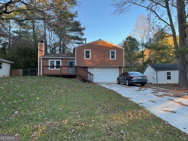 view of front facade featuring a garage, a deck, and a front lawn