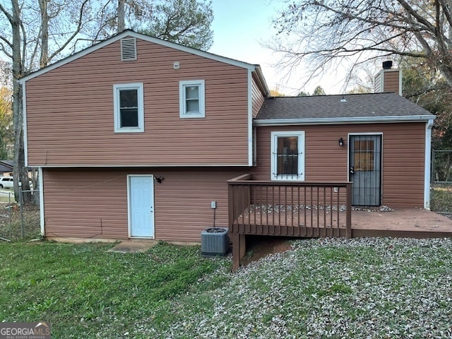 rear view of property with a yard and a deck