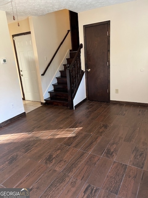 empty room featuring wood-type flooring and a textured ceiling