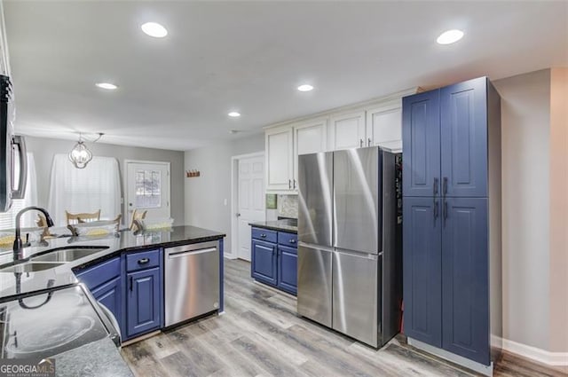 kitchen with sink, blue cabinetry, light hardwood / wood-style floors, and appliances with stainless steel finishes