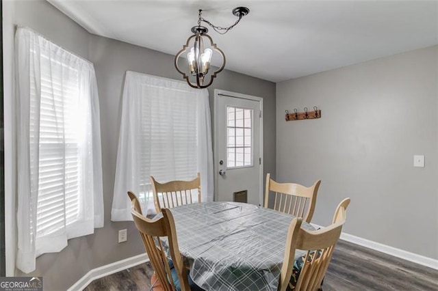 dining area featuring a notable chandelier and dark hardwood / wood-style flooring