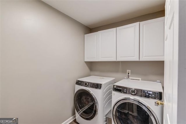 clothes washing area with cabinets and washer and dryer