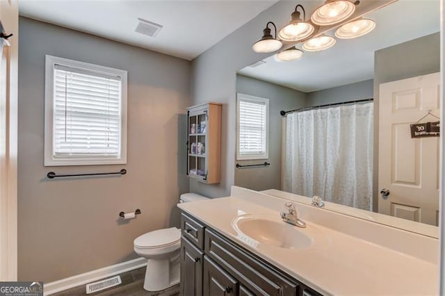 bathroom with vanity, toilet, and wood-type flooring