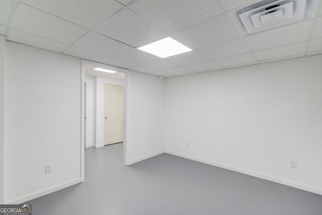 empty room with a paneled ceiling and concrete flooring