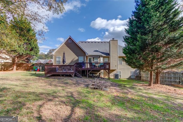 back of property featuring a lawn, cooling unit, and a deck