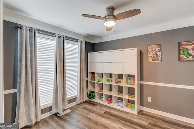 recreation room featuring hardwood / wood-style flooring, ceiling fan, and crown molding