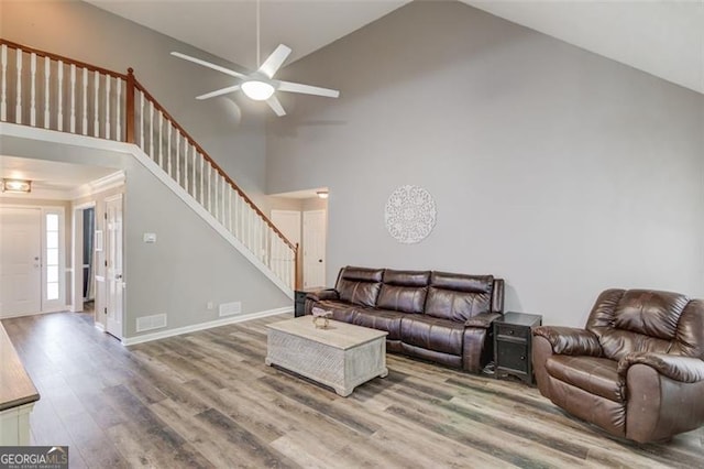 living room featuring ceiling fan, high vaulted ceiling, and wood-type flooring