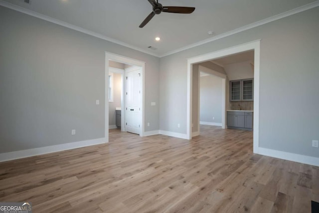 empty room featuring crown molding, light hardwood / wood-style flooring, and ceiling fan