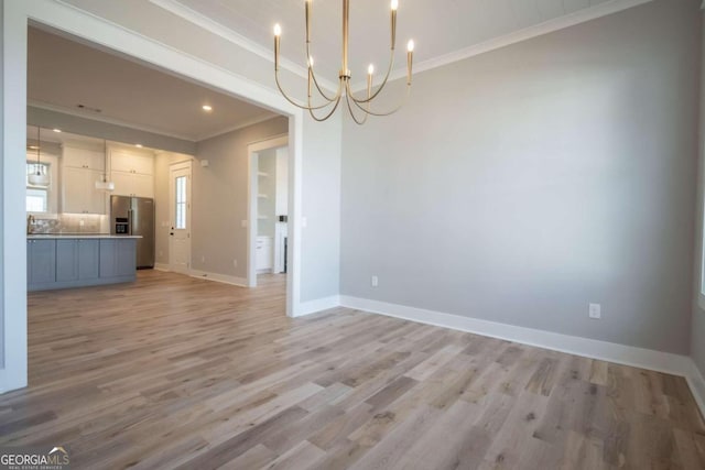 unfurnished dining area featuring a notable chandelier, light hardwood / wood-style floors, and ornamental molding