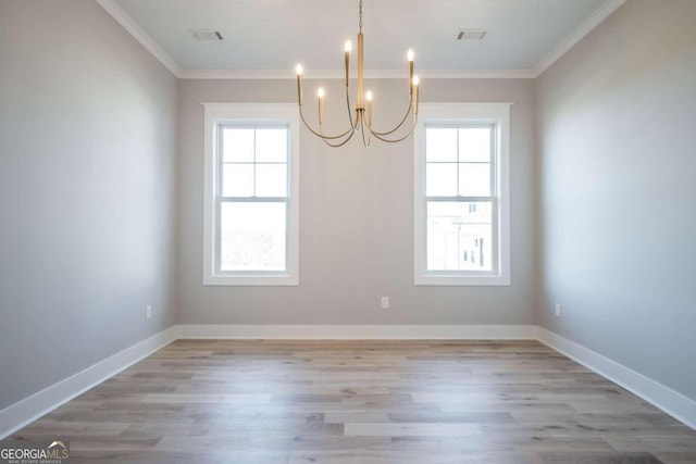 unfurnished dining area featuring an inviting chandelier, light hardwood / wood-style flooring, a wealth of natural light, and ornamental molding