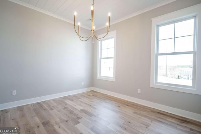 unfurnished room with a chandelier, light wood-type flooring, plenty of natural light, and ornamental molding