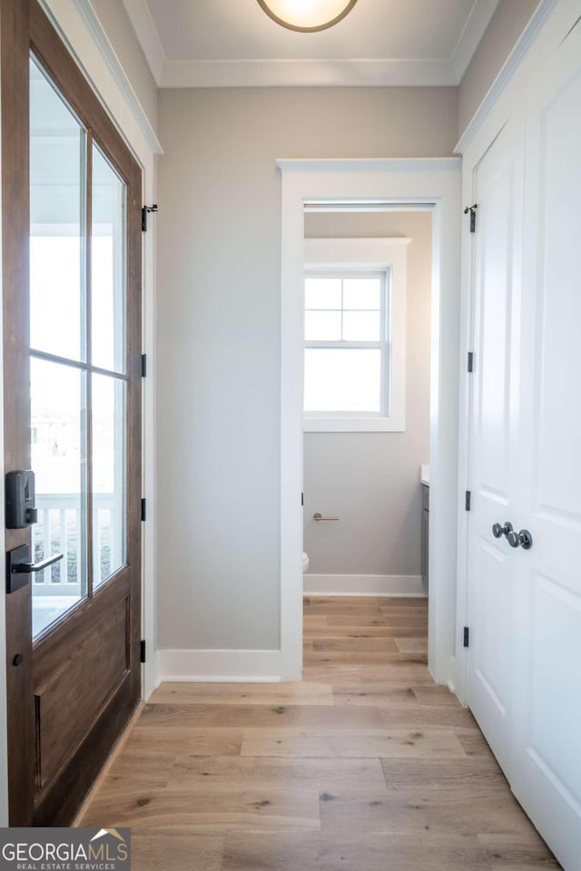 doorway featuring light hardwood / wood-style flooring and ornamental molding