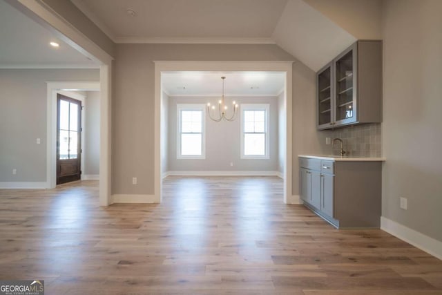 kitchen featuring a chandelier, gray cabinets, light hardwood / wood-style flooring, and crown molding