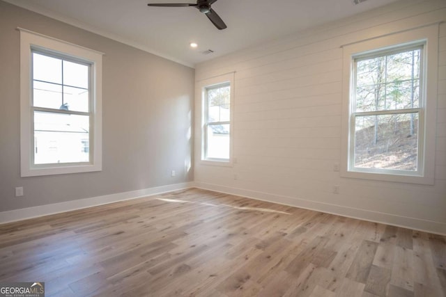 spare room featuring light wood-type flooring, ceiling fan, and crown molding