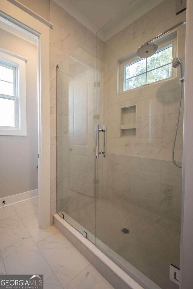 bathroom featuring a shower with shower door, a healthy amount of sunlight, and ornamental molding