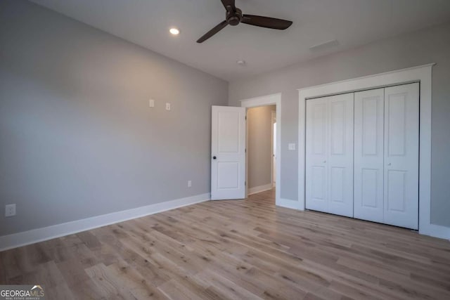 unfurnished bedroom with ceiling fan, a closet, and light wood-type flooring