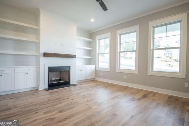 unfurnished living room featuring light hardwood / wood-style flooring, plenty of natural light, ornamental molding, and ceiling fan